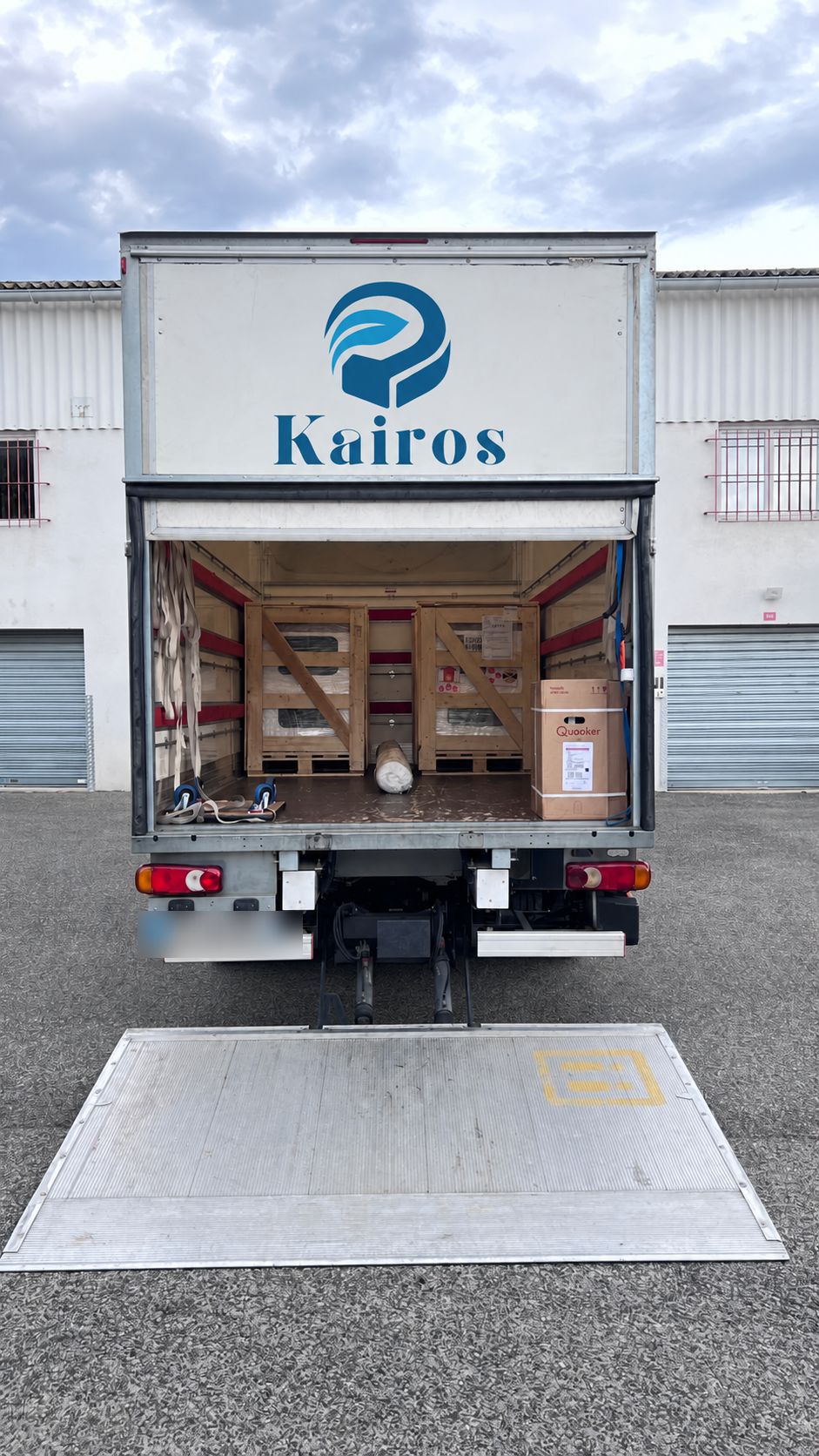 Intérieur d’un conteneur : mobilier emballé sous film et carton, calé et sanglé par l’équipe KAIROS.